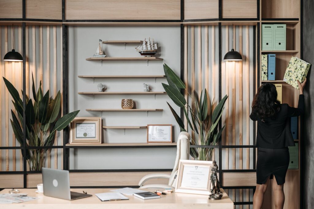 Elegant office interior with a businesswoman organizing files on a shelf.